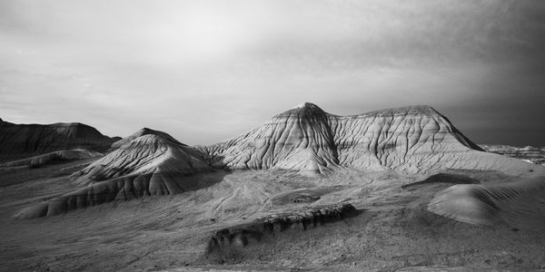 Black and white wide badlands with deeply eroded hills.